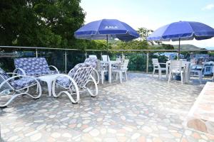 eine Gruppe von Stühlen und Tischen mit Sonnenschirmen auf einer Terrasse in der Unterkunft Quinta hotel villa las chanitas in Melgar