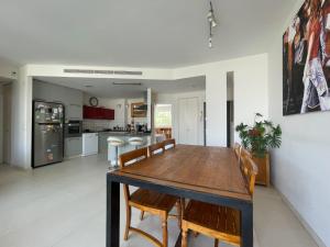 a dining room and kitchen with a wooden table and chairs at Spacious cosy & renovated flat in central Tel Aviv in Tel Aviv