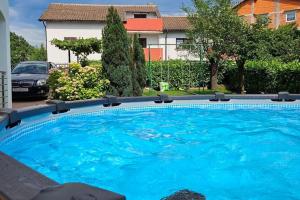 a large blue swimming pool in front of a house at Apartman Kristijan in Viskovo