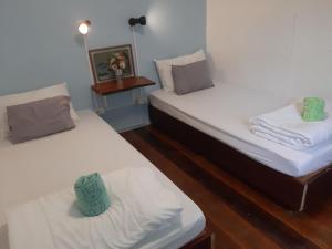 Habitación con 2 camas individuales y suelo de madera. en Ai's Attic Hostel en Ao Nang Beach