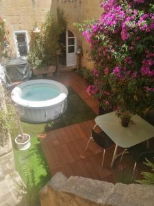 a garden with a bath tub and some flowers at Unique House of Character in centre of Mosta in Mosta