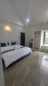 een slaapkamer met een groot wit bed in een kamer bij Cheeva at pai ชีวา แอท ปาย in Pai