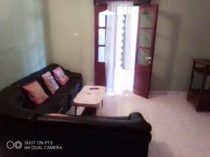 ein Wohnzimmer mit einem Sofa und einem Tisch in der Unterkunft Appartement F2 centre ville sécurisé in Diego Suarez