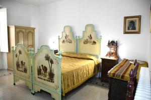 a bedroom with a bed and a dresser in it at Domo Peonia Bianca in Nuoro