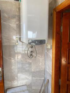 a bathroom with a shower with a tank on the wall at NaylaKonak in Cayeli