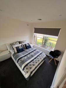 Un dormitorio con una cama grande y una ventana en West Beach House 4U, en Henley Beach South