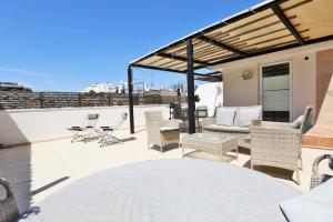 a patio with chairs and tables on a roof at Rothschild Allenby Penthouse 2BD in Tel Aviv