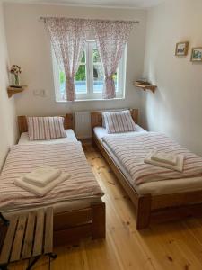 2 Betten in einem Zimmer mit Fenster in der Unterkunft Pension Soutěsky in Hřensko