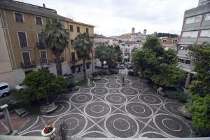a courtyard in a city with palm trees and buildings at Domo Peonia Bianca in Nuoro +7 photos