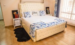 1 dormitorio con 1 cama grande con almohadas azules y blancas en The Fancy Luxurious 3 bedroom apartment, en Nakuru