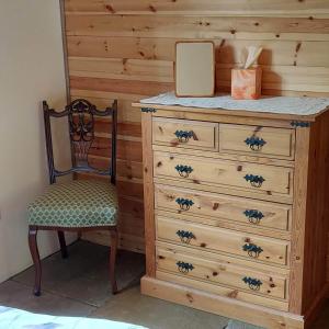 a wooden dresser with a chair and a mirror at Beautiful 1-Bed Lodge in Clifford Hereford in Hereford