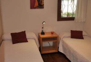 タラゴナにあるVilla besides the sea - 3 bedroomsのテーブルと窓のある部屋にベッドが2つある +18枚の写真