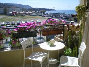 a balcony with a table and chairs and a parking lot at Orizzonte B&B in Cefalù