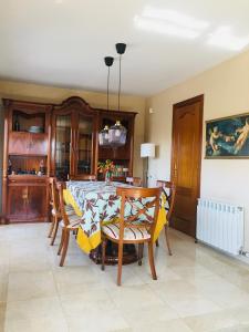 een eetkamer met een tafel en stoelen en een keuken bij Casa de Aurora in Rubí