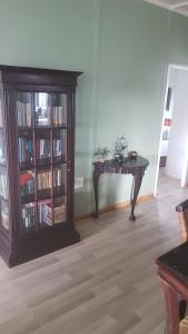 a room with a table and a book shelf with books at Porta Salutis in Port St Johns