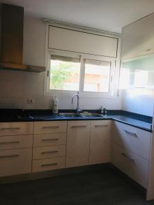 a kitchen with a sink and a window at Casa de Aurora in Rubí