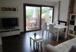 sala de estar con mesa, sillas y TV en Villa besides the sea - 3 bedrooms, en Tarragona
