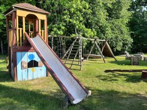 um parque infantil com um escorrega na relva em Mėgstantiems gaminti gamtoje 