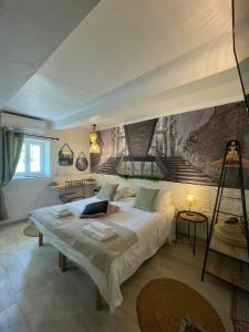 Hôtel Auberge Provençale في سانت رافائيل: غرفة نوم بسرير كبير عليها لوحة على الحائط