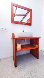 a bathroom sink with a mirror on a wall at Majango Bungalows in Kuta Lombok
