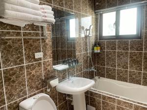 a bathroom with a sink and a toilet and a tub at 金門且停民宿 可包棟 好停車 近市區 in Jinning