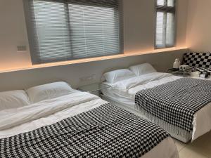 two beds sitting next to each other in a bedroom at 金門且停民宿 可包棟 好停車 近市區 in Jinning
