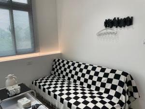 a black and white checkered couch in a room at 金門且停民宿 可包棟 好停車 近市區 in Jinning