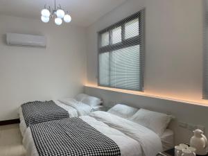 a bedroom with two beds and a window at 金門且停民宿 可包棟 好停車 近市區 in Jinning