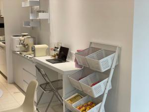 a kitchen with a white desk with baskets and a laptop at 金門且停民宿 可包棟 好停車 近市區 in Jinning