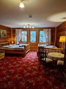 シュクラルスカ・ポレンバにあるWilla Gazdówka - Pokoje gościnneの赤いカーペットフロアのベッドルーム1室(ベッド2台付)