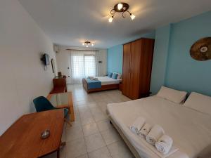 a bedroom with two beds and a table and a couch at Studios Erotokritos in Ammouliani