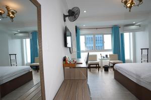 einen Spiegel in einem Zimmer mit 2 Betten und einem Tisch in der Unterkunft A25 Hotel - 14 Phó Đức Chính in Ho-Chi-Minh-Stadt
