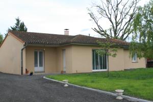 a small yellow house with a grass yard at villa bruyeres in Thiers
