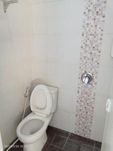 een kleine badkamer met een toilet en een douche bij MURAI Guesthouse Bali in Denpasar