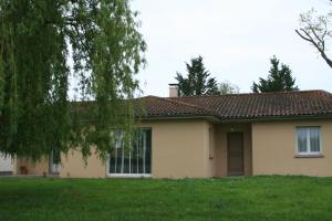 une maison avec une pelouse verte devant elle dans l'établissement villa bruyeres, à Thiers