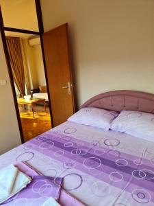 um quarto com uma cama com um edredão roxo em Apartment Tamara em Budva