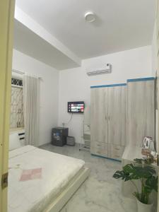Dieses weiße Zimmer verfügt über ein Bett und einen TV. in der Unterkunft Min homestay 5 in Buôn Ðũng + 1 Foto