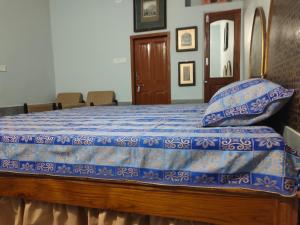 a bedroom with a bed with a blue comforter at Little prince guest house & homestay in Bikaner