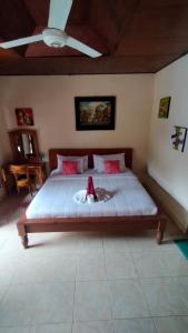 ein Schlafzimmer mit einem Bett mit einem ausgestopften Tier darauf in der Unterkunft Happy Inn 2 in Ubud