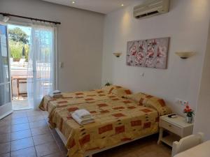 a bedroom with a bed and a door to a patio at Anna Studios in Agios Prokopios