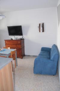 un soggiorno con divano blu e TV di Il garusolo a Pineto
