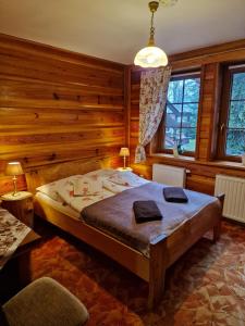 シュクラルスカ・ポレンバにあるWilla Gazdówka - Pokoje gościnneの木製の壁のベッドルーム1室(ベッド1台付)