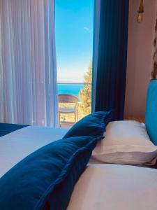 a bedroom with a bed with a view of the ocean at Alex Boutique Hotel in Himare