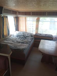niewielka sypialnia z łóżkiem i oknem w obiekcie Domek holenderski w mieście Sztynort
