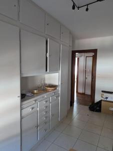 uma cozinha com armários brancos e uma bancada em appartement plein centre Saint die des Vosges em Saint-Dié-des-Vosges