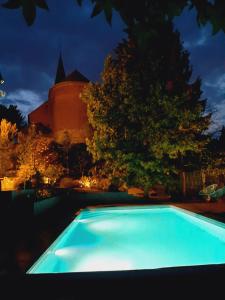 a swimming pool in front of a castle at night at Au pousseux d'église in Havay
