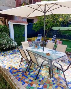 uma mesa com cadeiras e um guarda-sol num piso de mosaico em Casa Vacanze Smeralda Amalfi Coast em Vietri