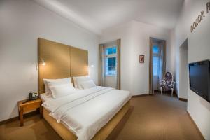 1 dormitorio con 1 cama grande y TV en Rimske Terme Resort - Hotel Sofijin dvor, en Rimske Toplice