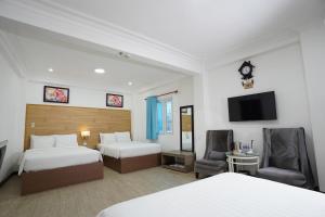 ein Hotelzimmer mit 2 Betten und einem TV in der Unterkunft A25 Hotel - 14 Phó Đức Chính in Ho-Chi-Minh-Stadt