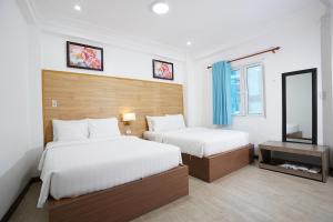 ein Hotelzimmer mit 2 Betten und einem Spiegel in der Unterkunft A25 Hotel - 14 Phó Đức Chính in Ho-Chi-Minh-Stadt